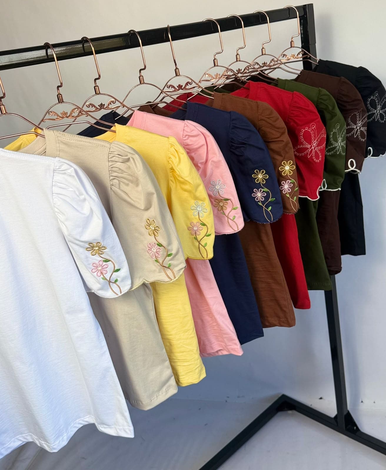 Arara com variedade de T-shirts bordadas da 22 T-Shirteria